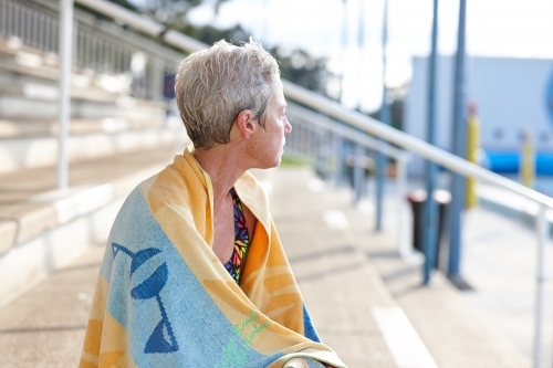 Active senior lady with towel at swimming pool - Australian Stock Image