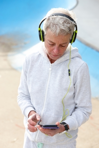 Active senior listening to music with headphones - Australian Stock Image