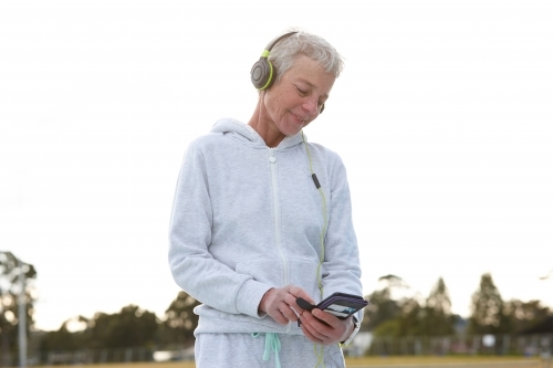 Active senior listening to music with headphones - Australian Stock Image