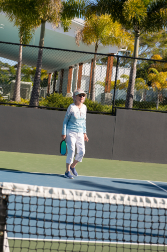 active senior woman playing pickleball outdoors - Australian Stock Image