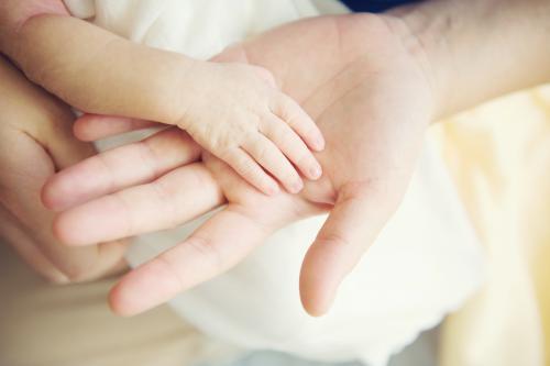 Adult hand with baby hand - Australian Stock Image