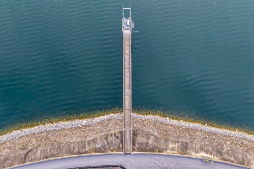 Aerial downward view of the Glenbawn Dam wall with the walkway leading out to the water intake - Australian Stock Image
