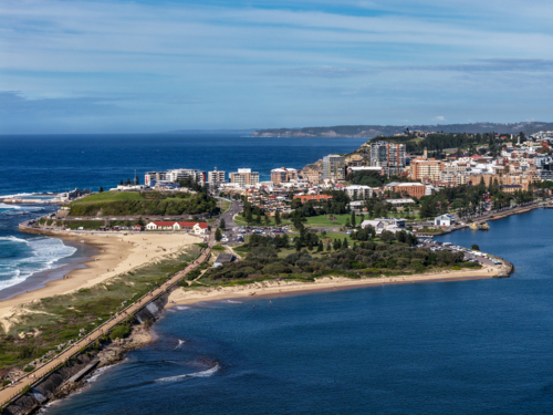 Aerial drone view of Horseshoe Beach and Nobbys Beach with Newcastle city skyline in the background. - Australian Stock Image