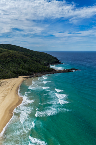 Aerial drone view of Seven Mile Beach in Forster showcasing a long stretch of sandy shoreline. - Australian Stock Image