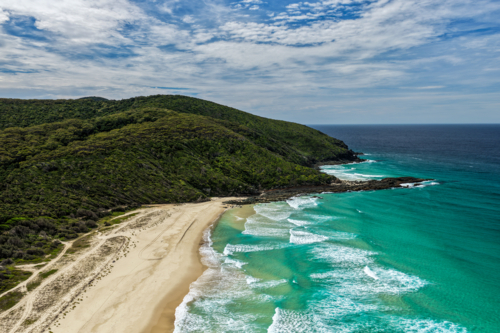 Aerial drone view of Seven Mile Beach in Forster showcasing a long stretch of sandy shoreline. - Australian Stock Image