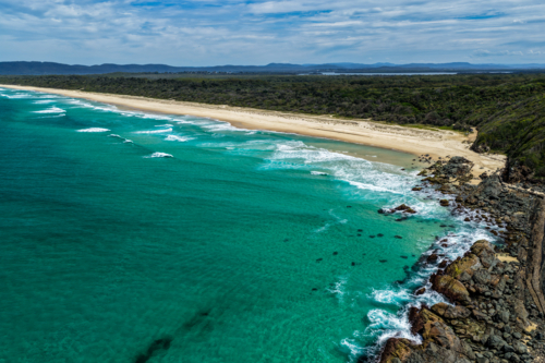 Aerial drone view of Seven Mile Beach in Forster showcasing a long stretch of sandy shoreline. - Australian Stock Image