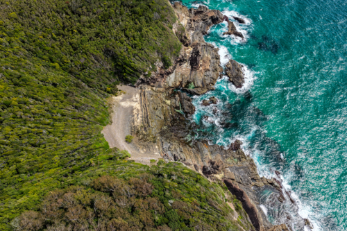 Aerial drone view over McBrides rockpool showing the natural rock formation along a rugged coastline - Australian Stock Image