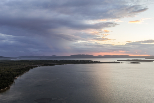 Aerial drone view over Pipers Bay in Forster, New South Wales, Australia with cloudy sky. - Australian Stock Image