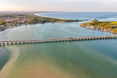 Aerial image capturing the calm blue waters of Wallis Lake with the Tuncurry Forster Bridge - Australian Stock Image