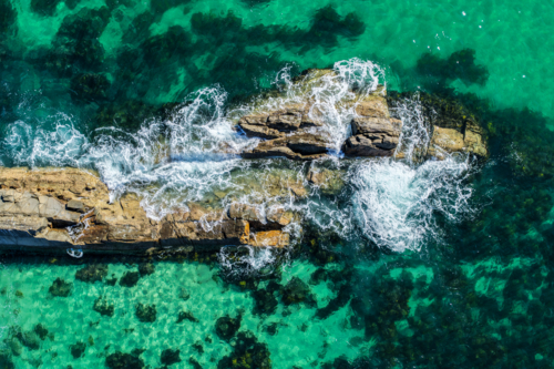 Aerial image capturing the rugged rock pools and turquoise water at The Tanks in Forster - Australian Stock Image