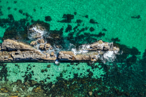 Aerial image capturing the rugged rock pools and turquoise water at The Tanks in Forster - Australian Stock Image
