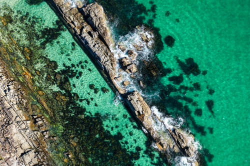 Aerial image capturing the rugged rock pools and turquoise water at The Tanks in Forster - Australian Stock Image