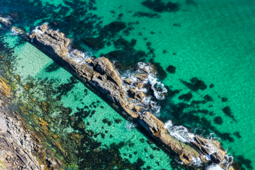 Aerial image capturing the rugged rock pools and turquoise water at The Tanks in Forster - Australian Stock Image