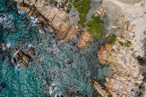 Aerial image capturing the turquoise waters and rocky shoreline of Rose Bay, Bowen - Australian Stock Image