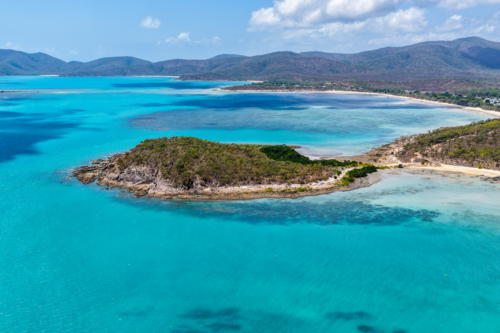 Aerial image of Hydeaway Bay, capturing its brilliant turquoise water, rocky headlands - Australian Stock Image