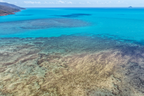 Aerial image of Hydeaway Bay, capturing its brilliant turquoise water, rocky headlands - Australian Stock Image