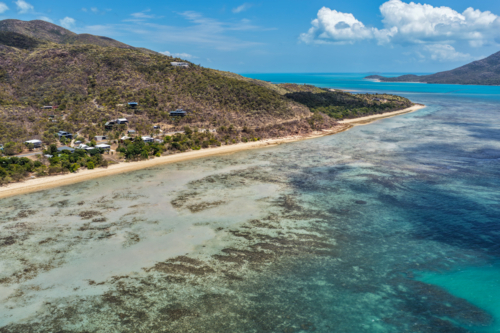 Aerial image of Hydeaway Bay, capturing its brilliant turquoise water, rocky headlands - Australian Stock Image