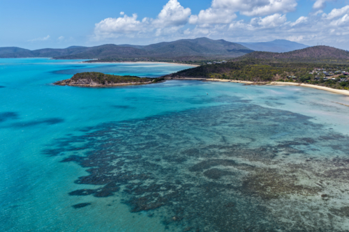 Aerial image of Hydeaway Bay, capturing its brilliant turquoise water, rocky headlands - Australian Stock Image