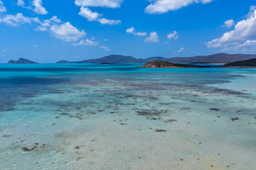 Aerial image of Hydeaway Bay, capturing its brilliant turquoise water, rocky headlands - Australian Stock Image