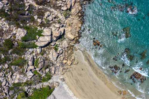 Aerial image showcasing the rugged rocky coastline of Rose Bay in Bowen - Australian Stock Image