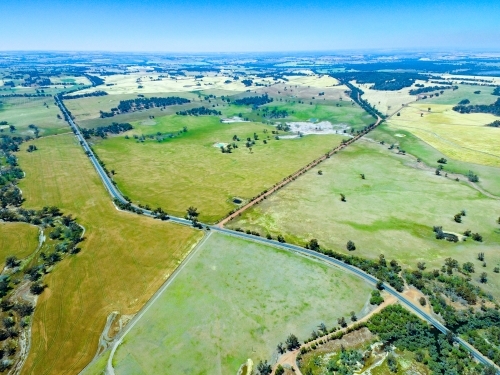 Aerial landscape over farming land with road cutting through