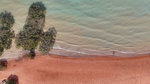 Aerial of aqua water meeting red sand - Australian Stock Image