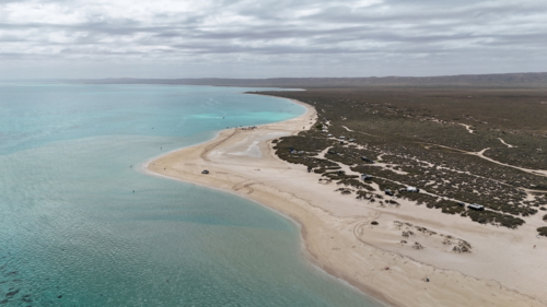 Aerial of beach camps meeting crystal blue water - Australian Stock Image