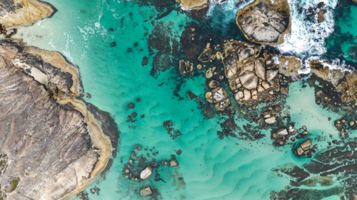 Aerial of beach with aqua water and large rocks - Australian Stock Image