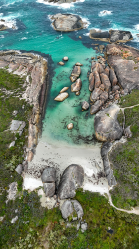 Aerial of beach with aqua water and large rocks - Australian Stock Image