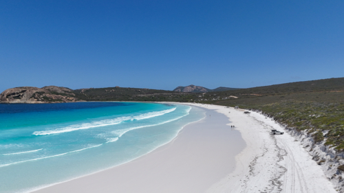 Aerial of beach with white sand and crystal blue water on a sunny day - Australian Stock Image