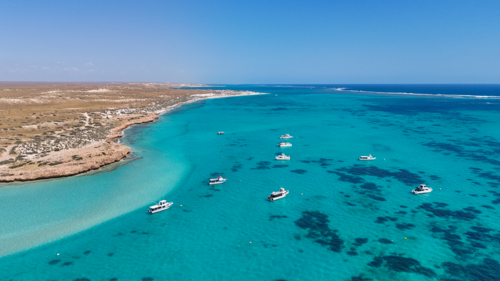 Aerial of boats above the reef close to land - Australian Stock Image
