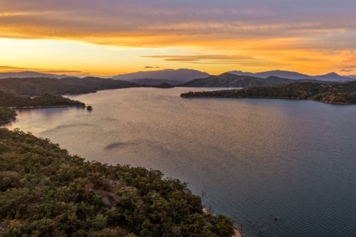 Aerial of Glenbawn Dam at sunset in NSW Australia. Drone view of calm dam waters - Australian Stock Image