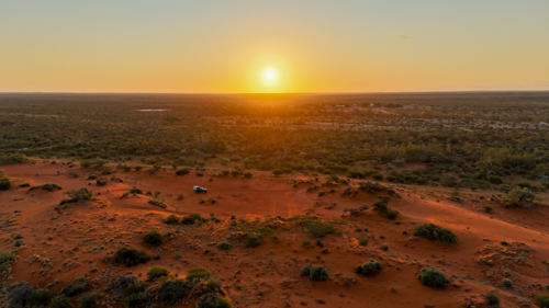Aerial of golden hour in a remote red sand landscape - Australian Stock Image