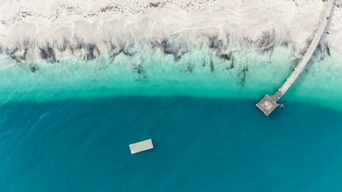 Aerial of jetty and pontoon at a beach - Australian Stock Image