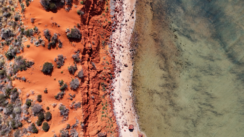 Aerial of red cliff at a remote beach - Australian Stock Image