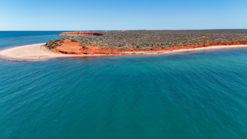 Aerial of red cliff point meeting the ocean - Australian Stock Image