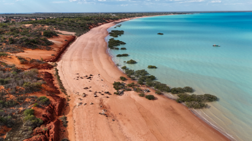 Aerial of red sand beach with blue water - Australian Stock Image