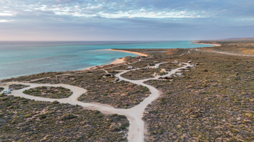 Aerial of remote beachside campsite by the reef - Australian Stock Image