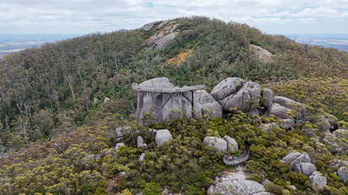 Aerial of remote lookout on top of large granite boulder - Australian Stock Image