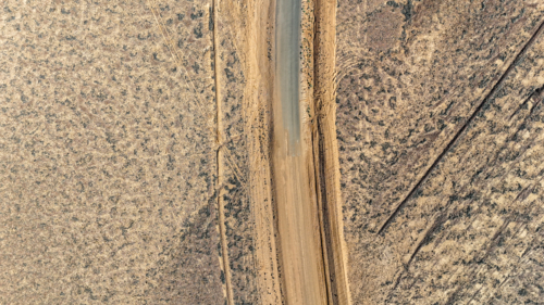 Aerial of where the dirt road meets the tar - sealed to unsealed road - Australian Stock Image