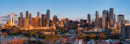 Aerial panorama of high rise buildings in a city skyline in golden evening lighting - Australian Stock Image