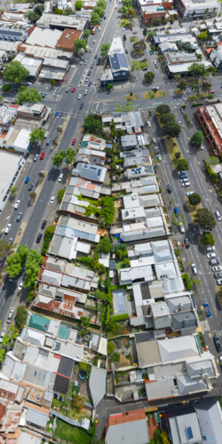Aerial panorama view of suburban housing on a triangular city block bordered by busy roads - Australian Stock Image