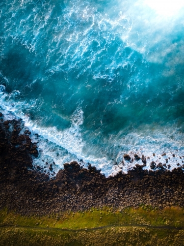 Aerial Perspective - Green Grass, a Dirt Trail, and Crashing Blue Waves