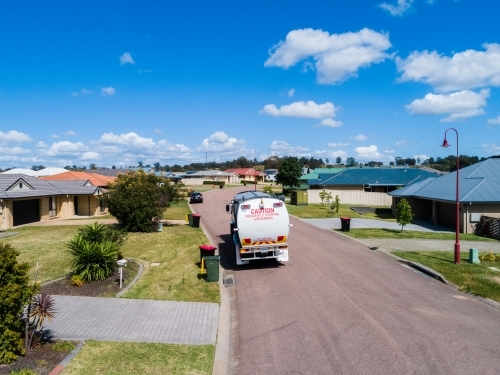 Aerial photo of a garbage truck emptying waste bins along suburban street - Australian Stock Image