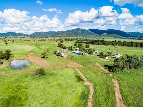 Aerial photo of dam and track to farm through green paddocks - Australian Stock Image