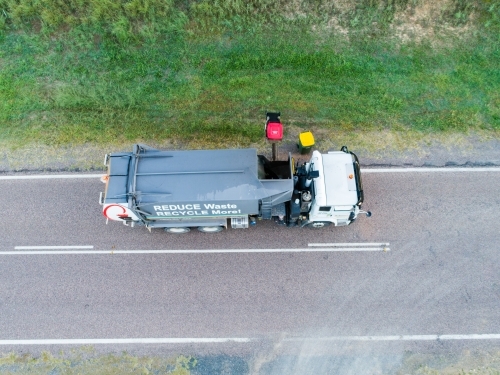 Aerial photo of garbage truck emptying bins in rural location - Australian Stock Image