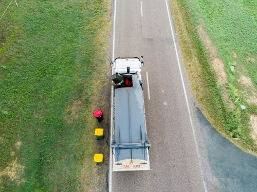 Aerial photo of garbage truck emptying bins in rural location - Australian Stock Image
