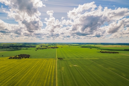 aerial shot of a big open field under cloudy blue skies - Australian Stock Image