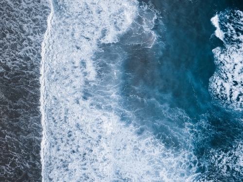 Aerial shot of waves rolling in from the ocean