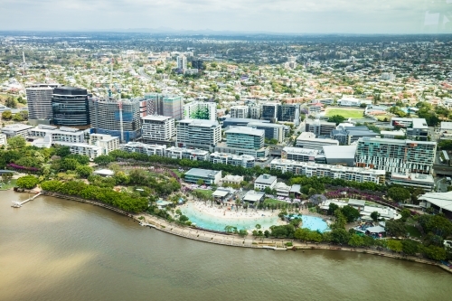 Aerial view across the Brisbane River towards Southbank Parklands and the suburbs beyond - Australian Stock Image